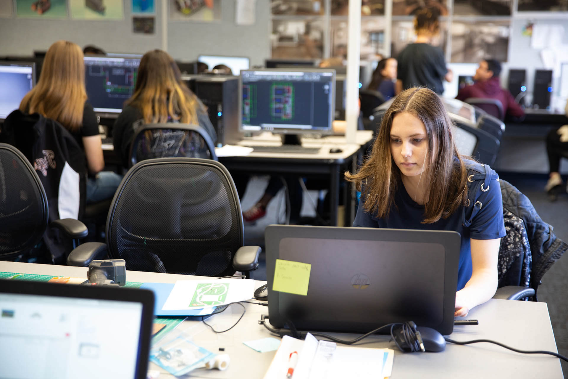 Woman in a class working on a laptop.