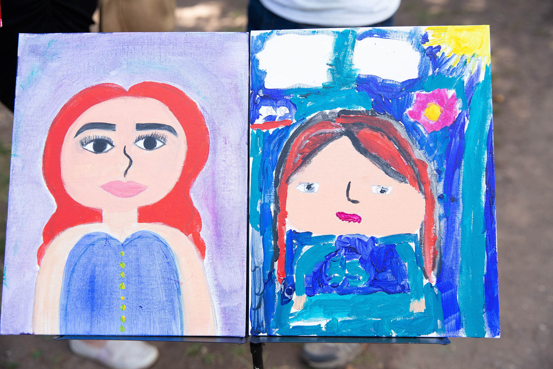 Children showing paintings they made at an art show.