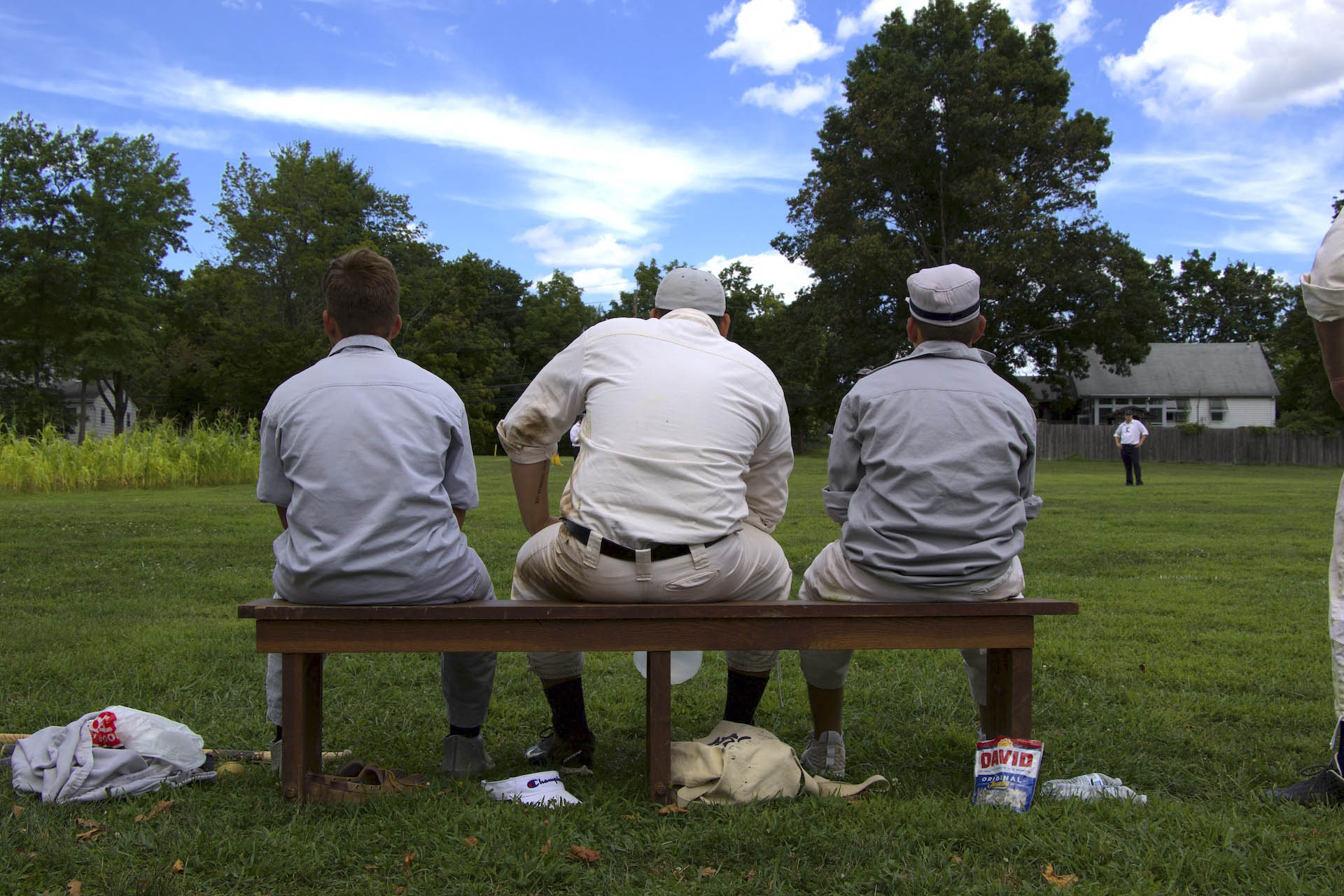 players of the Liberty Baseball Club team sit on a bench