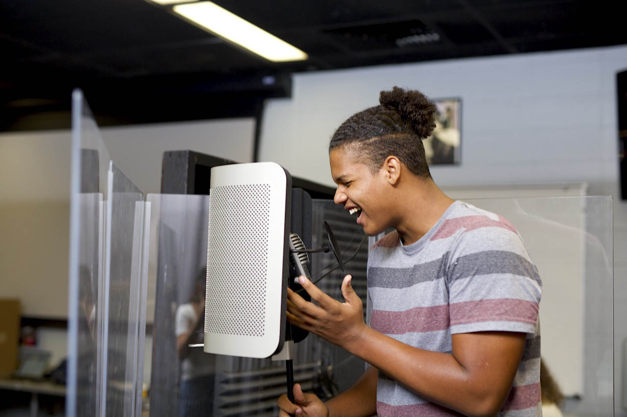 A music student singing into a recording microphone.