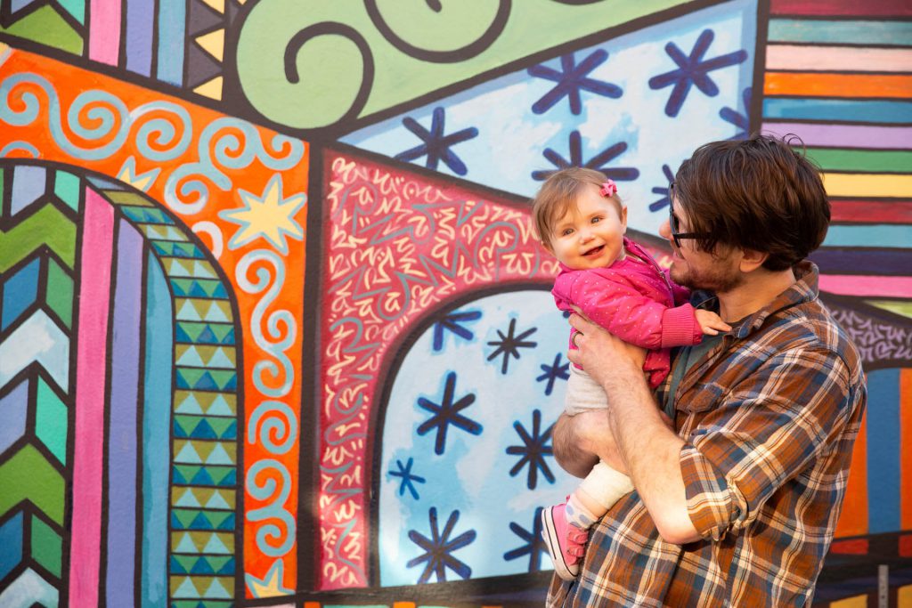 Eric Truchan & Birdie infront of a mural.