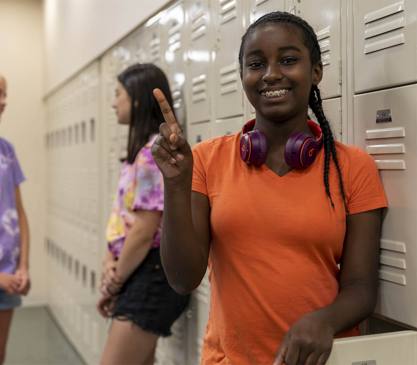 A happy student standing by lockers in a Middlesex County school.