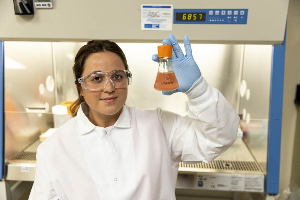 A laboratory worker holding a vial.